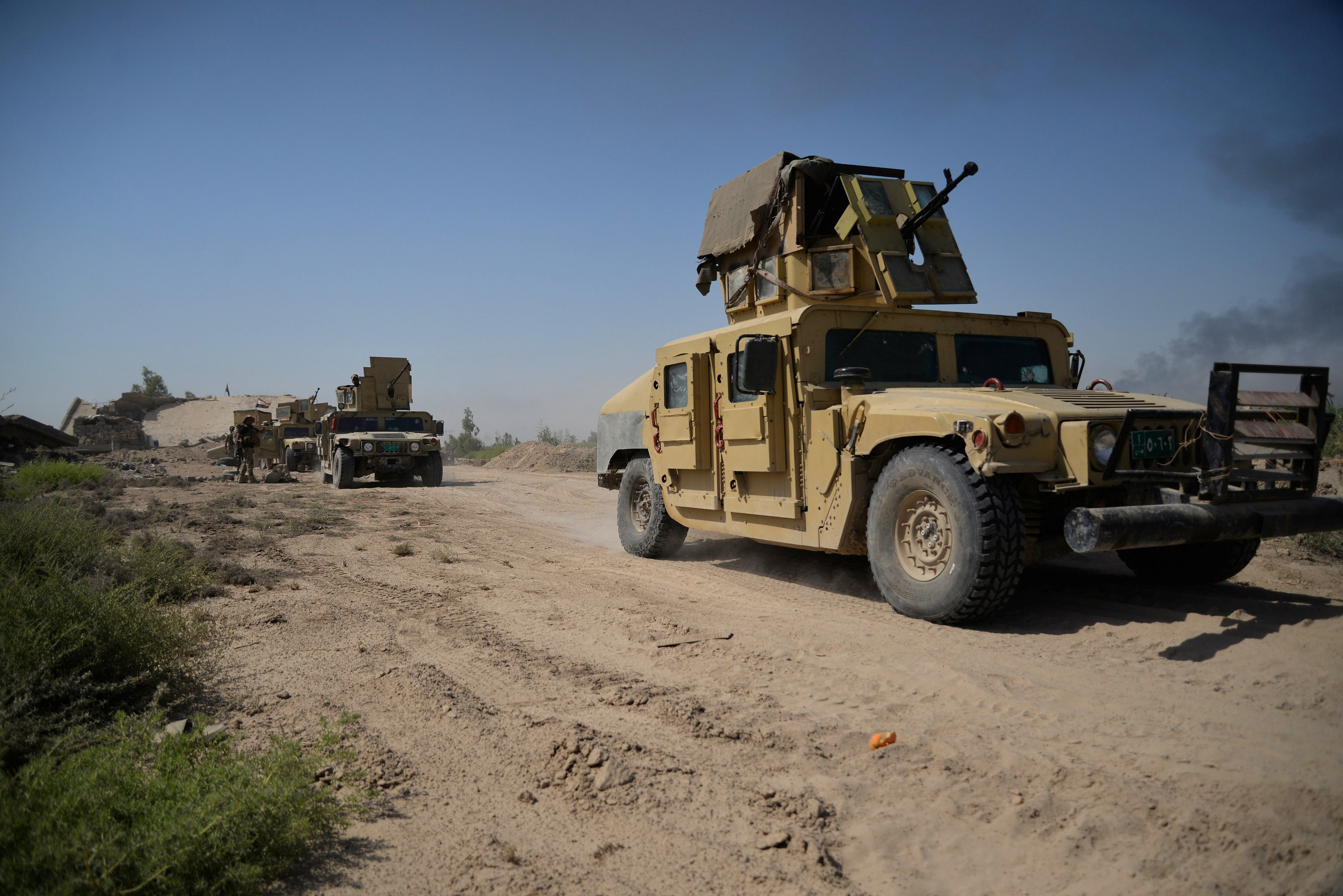 Vehicles of the Iraqi security forces are seen on the outskirts of Falluja