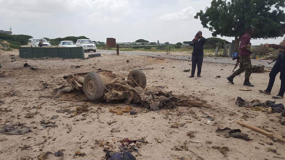 Somali soldiers stand near the wreckage of a car used in a suicide car bomb attack. [Photo: Twitter]