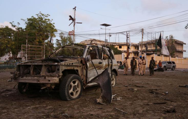The wreckage of an unidentified car destroyed in an explosion is seen as Somali security officers secure the scene of a suicide car explosion in front of the national theatre in Mogadishu