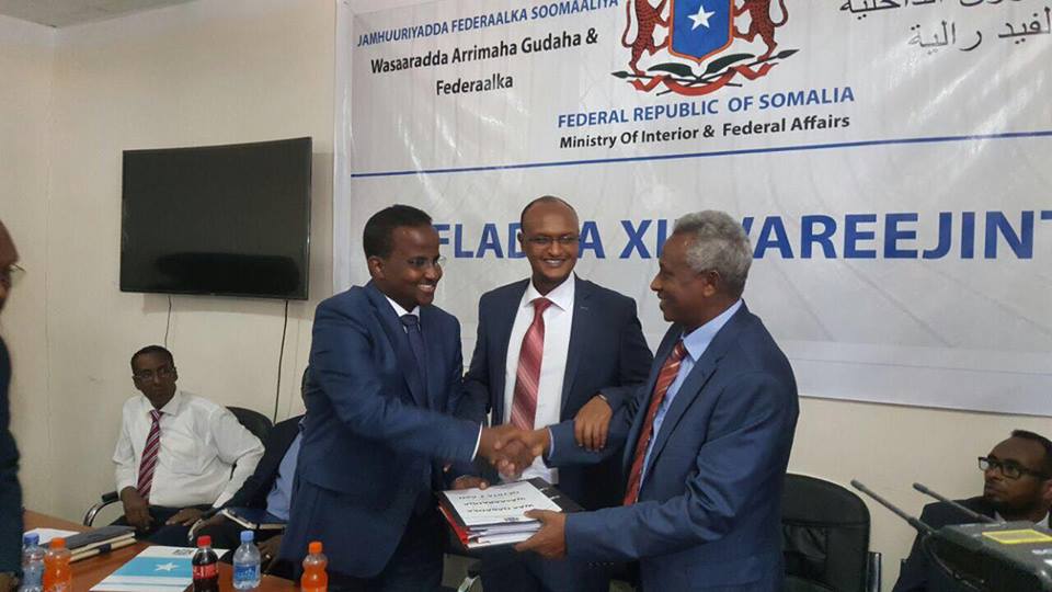 The former Minister of Interior Abdirahman Odowaa presents handover notes to the new Minister of Interior Abdi Farah Juha. [Photo: Facebook]