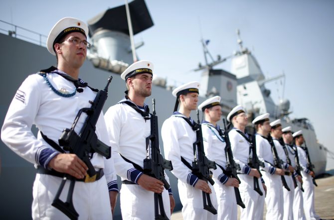 German Navy armed personnel stand in front of the Frigate Hamburg, docked at Port Rashid, in Dubai